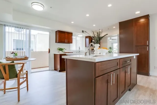 a kitchen with a sink a table and chairs in it