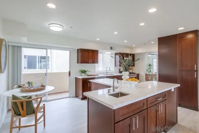 a kitchen with kitchen island granite countertop a sink a counter top space and stainless steel appliances