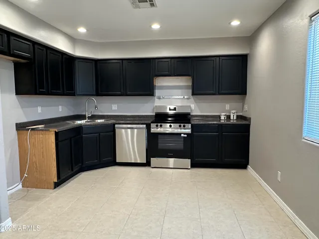 a kitchen with stainless steel appliances granite countertop a stove a sink and a microwave