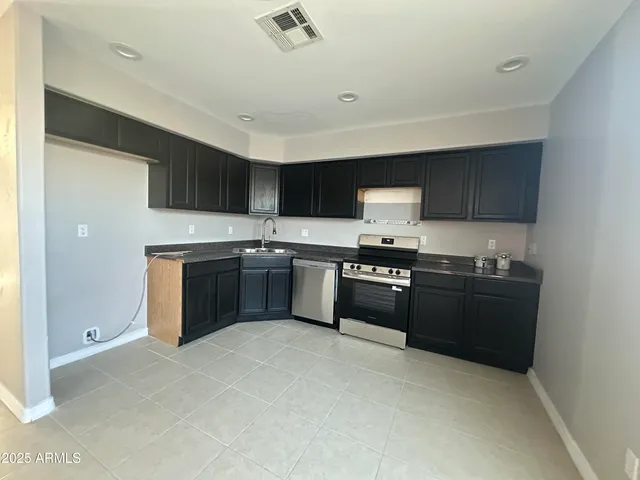 a kitchen with granite countertop a stove top oven sink and cabinets