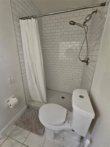 a white toilet sitting next to a shower curtain