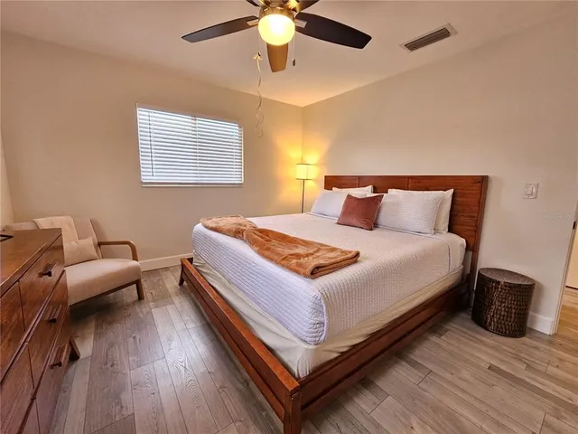 a bedroom with a bed and wooden floor