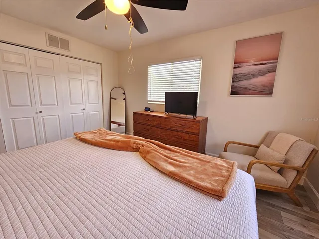 a bedroom with a bed and wooden floor