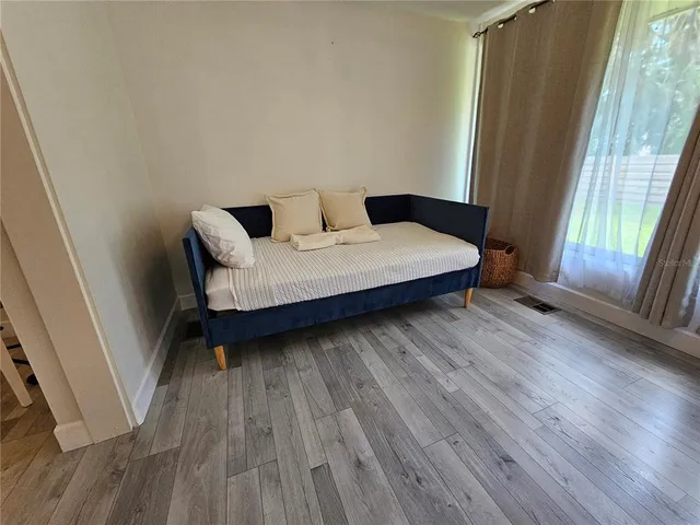 a bedroom with a bed and wooden floor