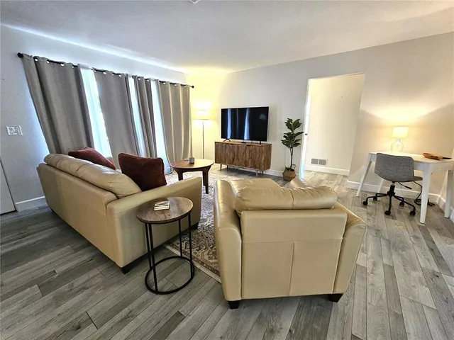 a living room with furniture and a wooden floor