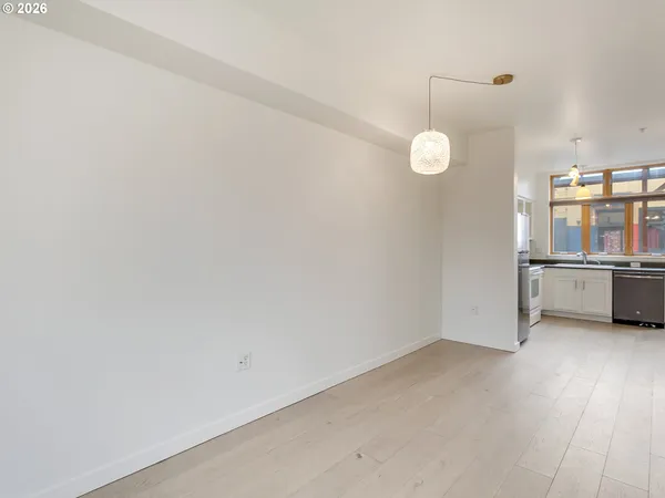 a white kitchen with stainless steel appliances granite countertop a stove a sink and a refrigerator