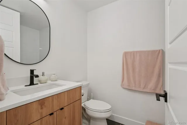 a bathroom with a sink vanity mirror and toilet