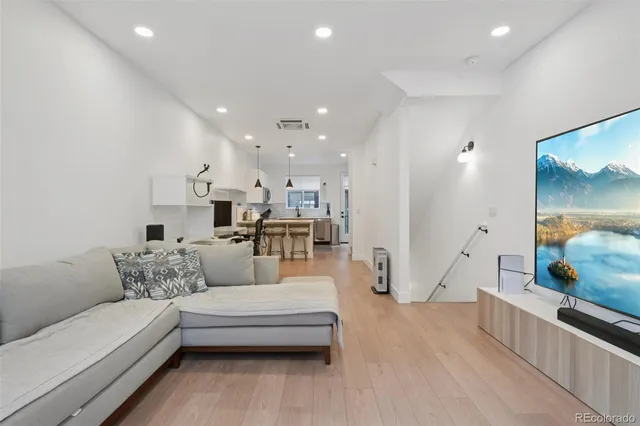 a living room with furniture and a view of kitchen