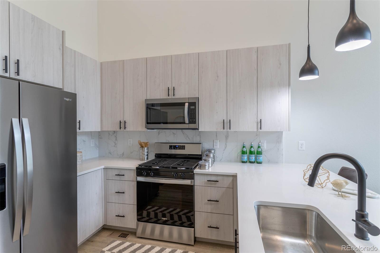 2360 West 49th Avenue Denver, CO 80221 - Photo 11 of 25 a kitchen with stainless steel appliances a refrigerator sink and stove