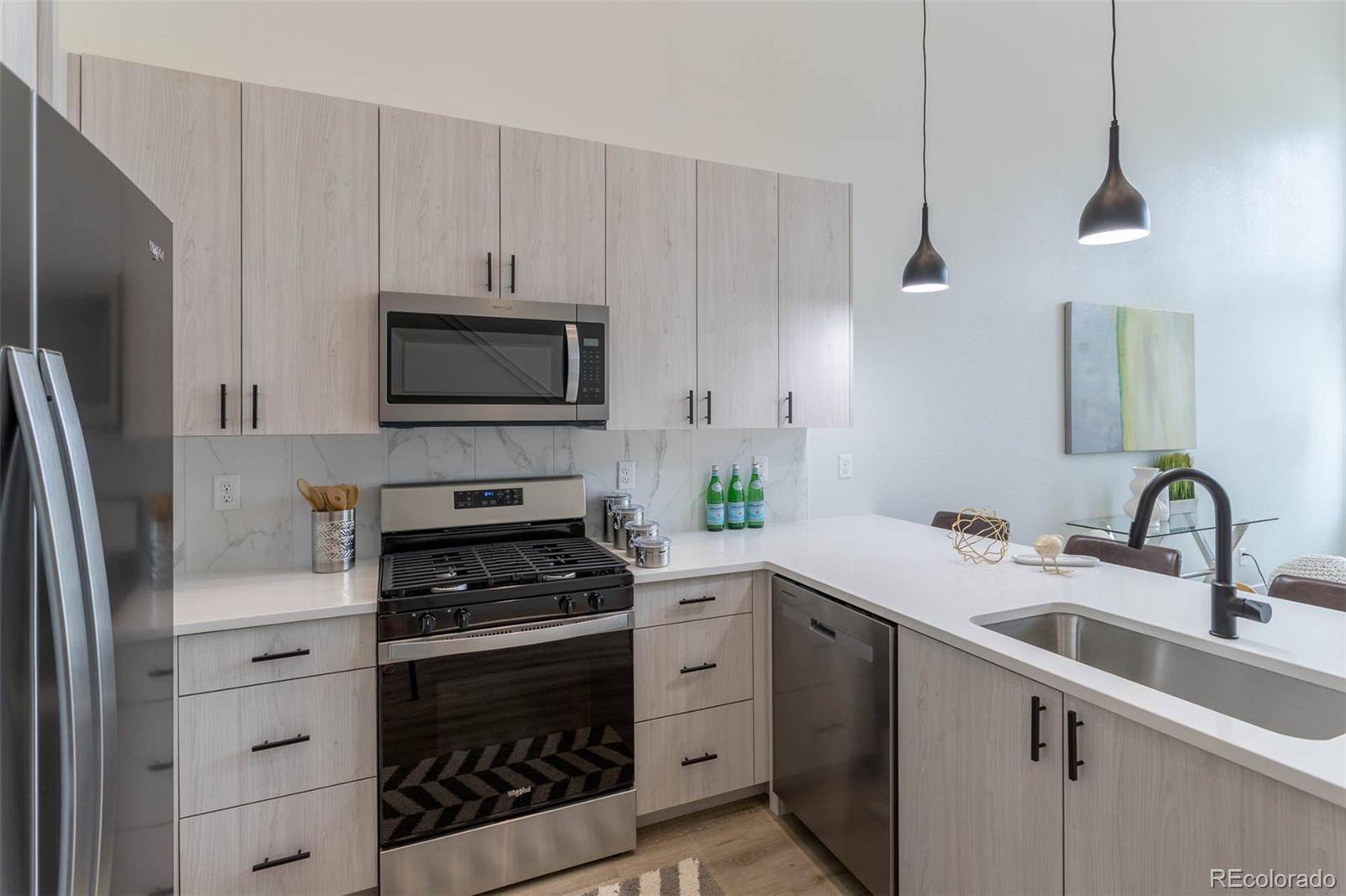 2360 West 49th Avenue Denver, CO 80221 - Photo 12 of 25 a kitchen with appliances a sink a stove and cabinets