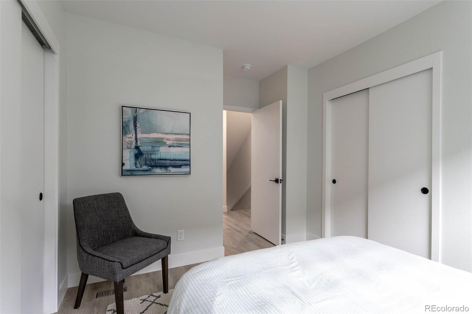 2360 West 49th Avenue Denver, CO 80221 - Photo 14 of 25 a bedroom with a bed and a chair