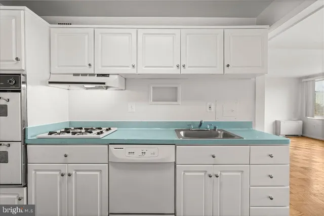 a kitchen with granite countertop white cabinets and a stove