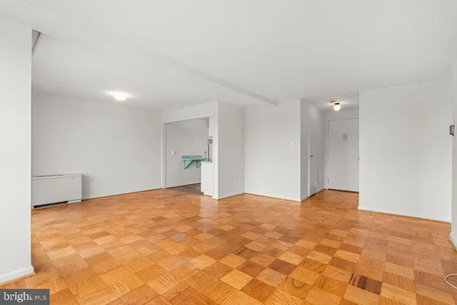 a view of an empty room with closet and a window