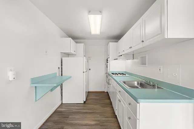 a kitchen with granite countertop a sink and dishwasher a stove with wooden floor