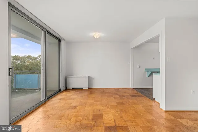 a view of empty room with wooden floor