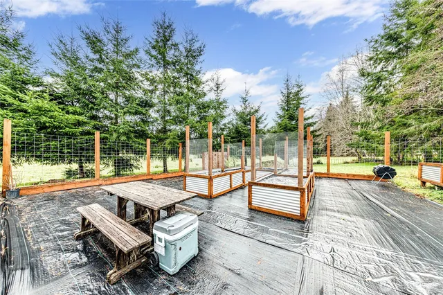 a view of a patio with a table and chairs next to a yard