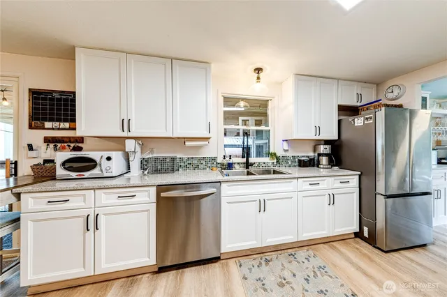 a kitchen with white cabinets sink and white appliances