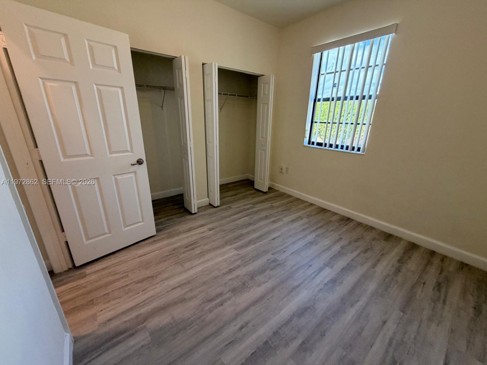 11520 Southwest 248th Lane Homestead, FL 33032 - Photo 11 of 15 an empty room with wooden floor and windows
