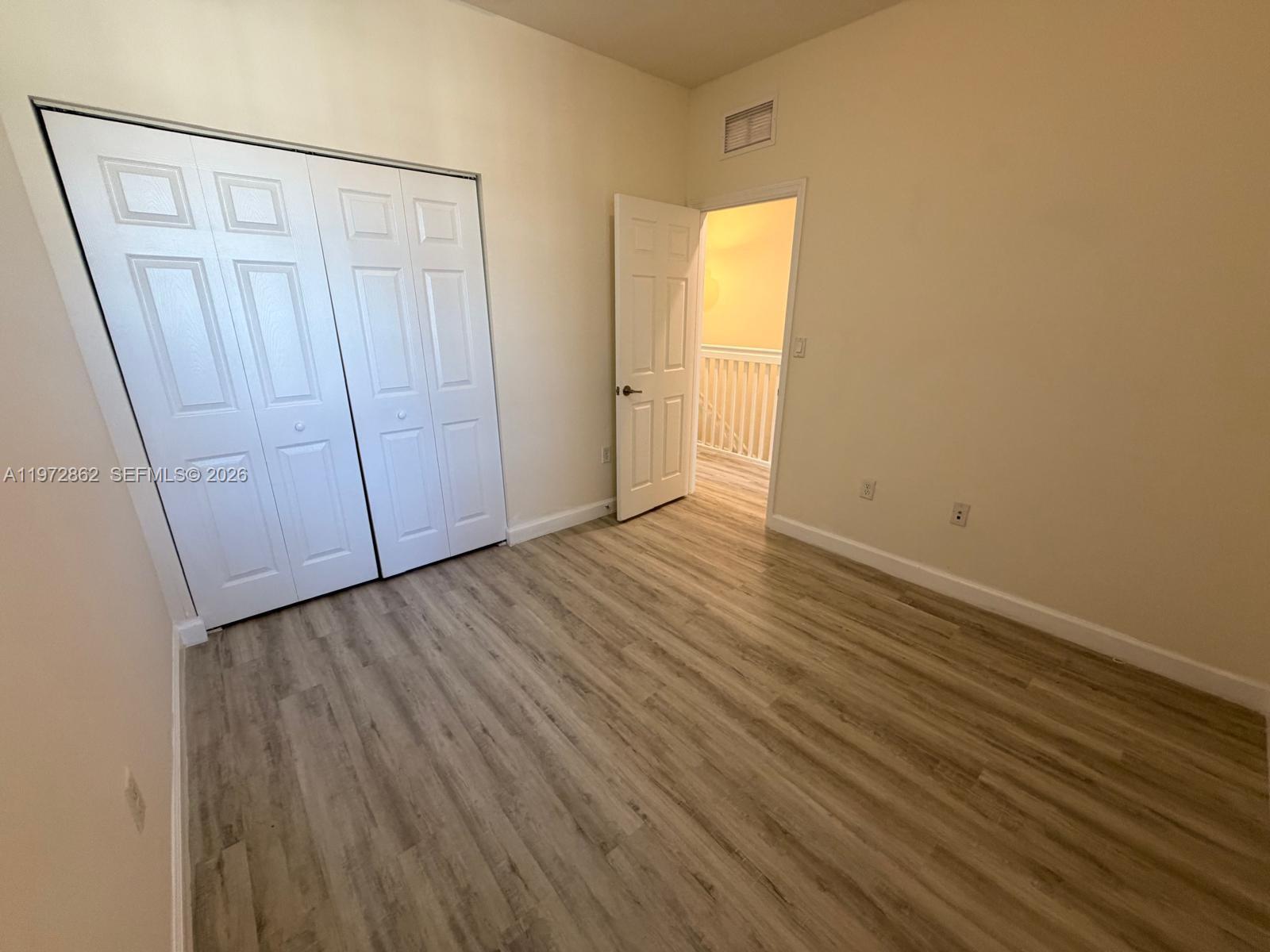11520 Southwest 248th Lane Homestead, FL 33032 - Photo 13 of 15 an empty room with wooden floor and windows