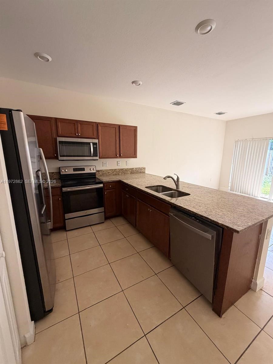 11520 Southwest 248th Lane Homestead, FL 33032 - Photo 2 of 15 a kitchen with a sink and a stove top oven