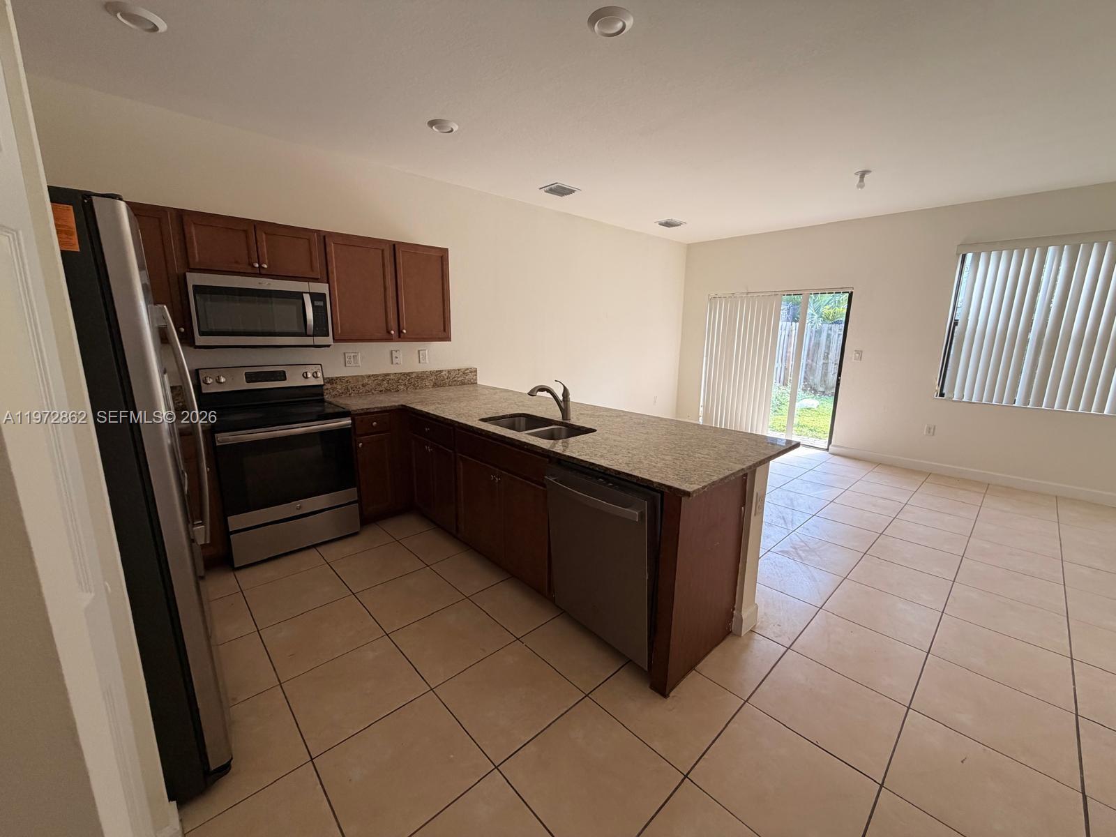 11520 Southwest 248th Lane Homestead, FL 33032 - Photo 3 of 15 a kitchen with stainless steel appliances granite countertop a sink and cabinets