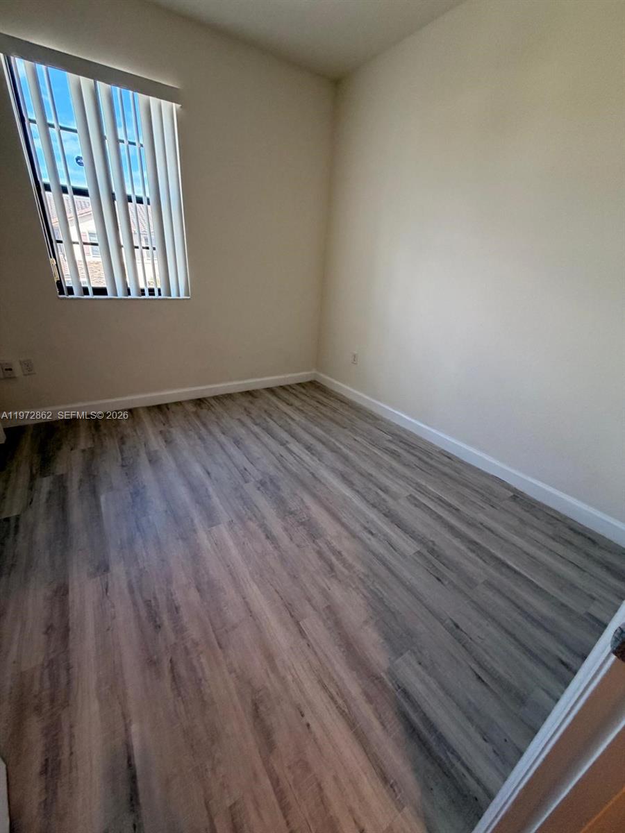 11520 Southwest 248th Lane Homestead, FL 33032 - Photo 9 of 15 a view of an empty room with wooden floor and a window