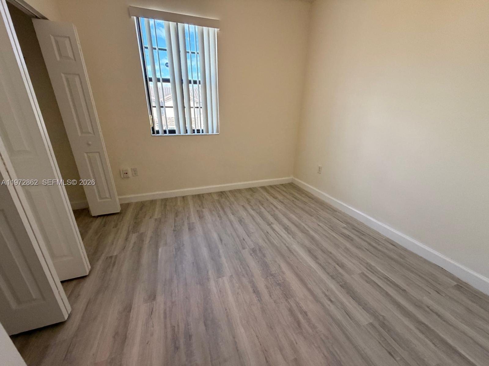 11520 Southwest 248th Lane Homestead, FL 33032 - Photo 10 of 15 an empty room with wooden floor and windows