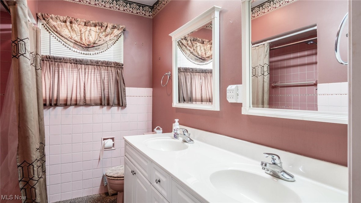 1950 Newark Road Zanesville, OH 43701 - Photo 19 of 39 Bathroom with a shower with curtain, vanity, toilet, and tile walls
