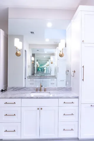 a bathroom with a granite countertop sink and a mirror
