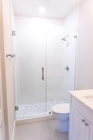 a bathroom with a shower a toilet and sink