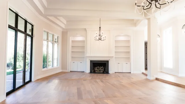a view of an empty room with a fireplace and a window