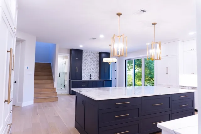 a kitchen with a sink a counter space and wooden floor