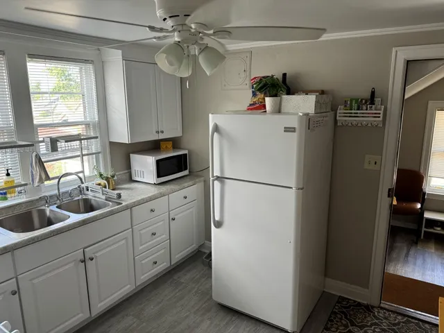 a kitchen with appliances a refrigerator a sink and cabinets