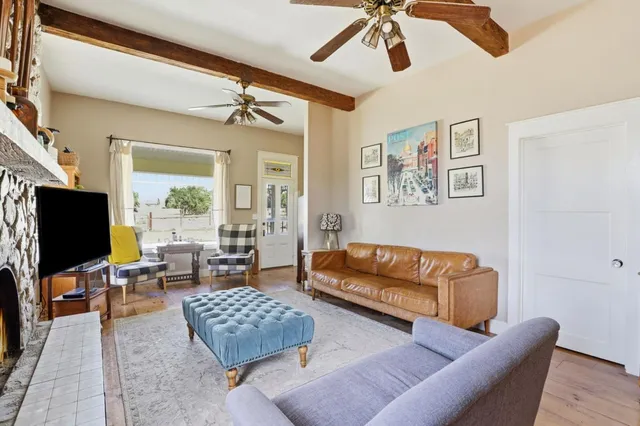 a living room with furniture ceiling fan and a flat screen tv
