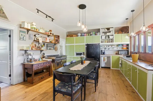 a view of a dining room and livingroom with furniture wooden floor a chandelier