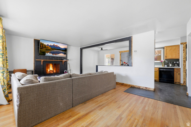 1486 3rd Street Ogden, UT 84404 - Photo 5 of 26 Living space featuring wood-finish flooring, a black tiled fireplace with a mantel, and an open pass-through window with a dark trim