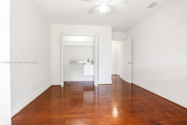 a view of an empty room with wooden floor