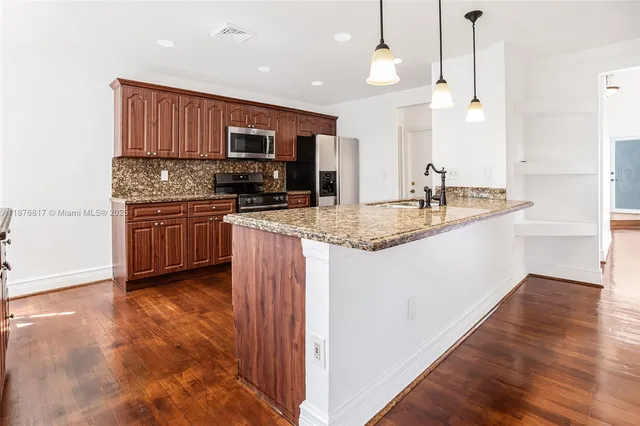 a kitchen with stainless steel appliances granite countertop a sink stove and refrigerator