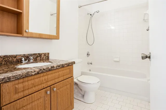 a bathroom with a granite countertop sink a toilet and shower