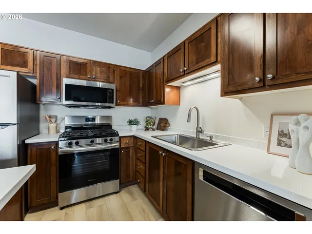 a kitchen with stainless steel appliances a sink stove and microwave