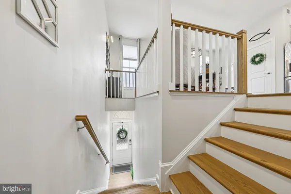 a view of staircase with lots of frames on wall and a window