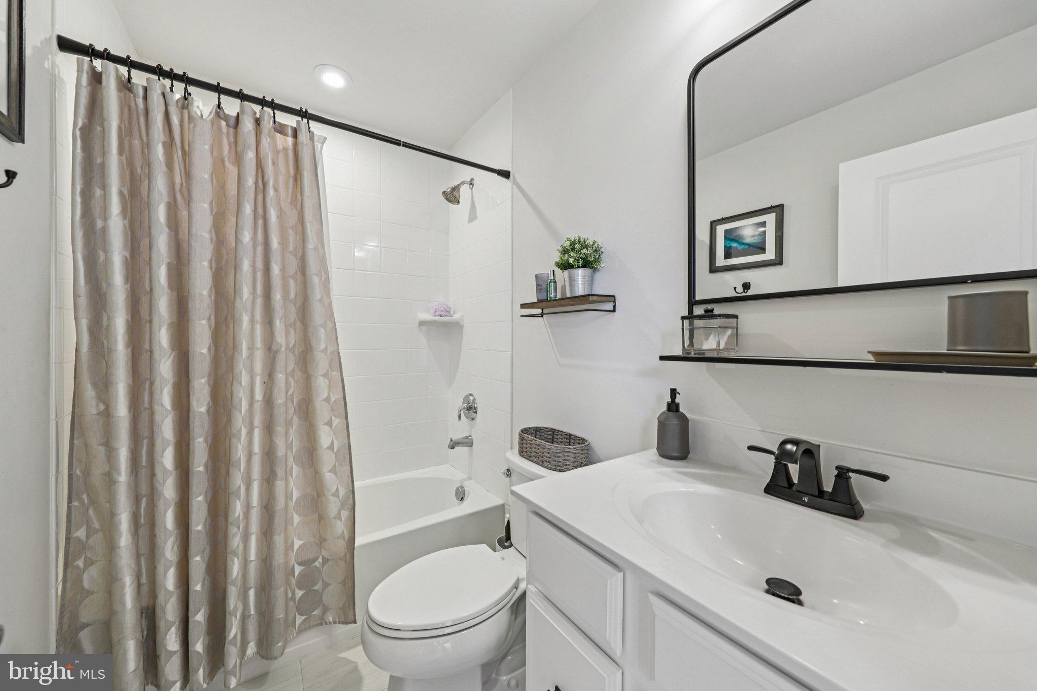 1687 Aspen Poplar Road Dumfries, VA 22026 - Photo 43 of 69 a bathroom with a sink a toilet and shower curtain