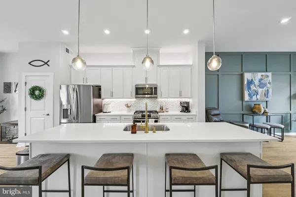 a kitchen with kitchen island white cabinets and stainless steel appliances
