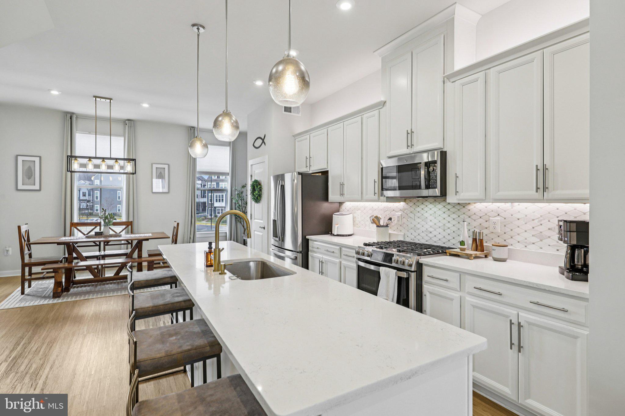 1687 Aspen Poplar Road Dumfries, VA 22026 - Photo 6 of 69 a kitchen with kitchen island white cabinets and stainless steel appliances