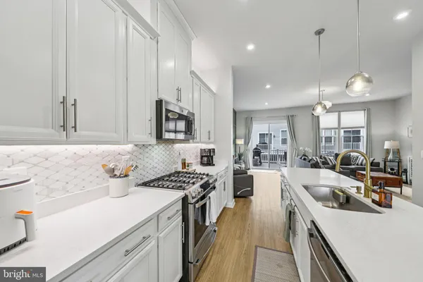 a dining room with wooden floor a chandelier a wooden table and chairs