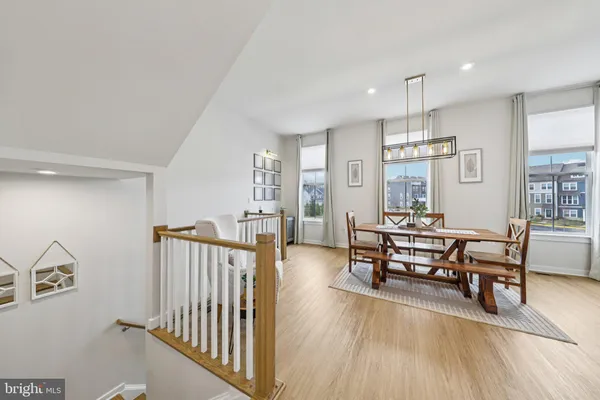 a dining room with wooden floor a chandelier a wooden table and chairs