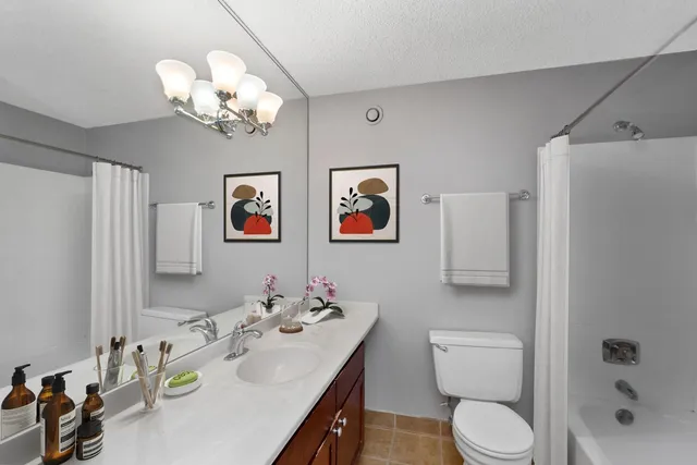 a bathroom with a granite countertop toilet sink and mirror