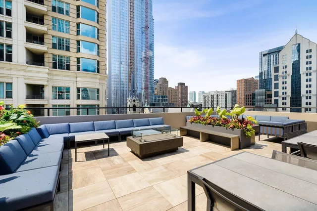 a view of a roof deck with couches and potted plants