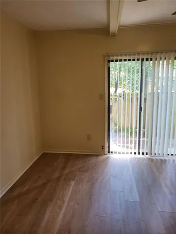 a view of a room with wooden floor and a window