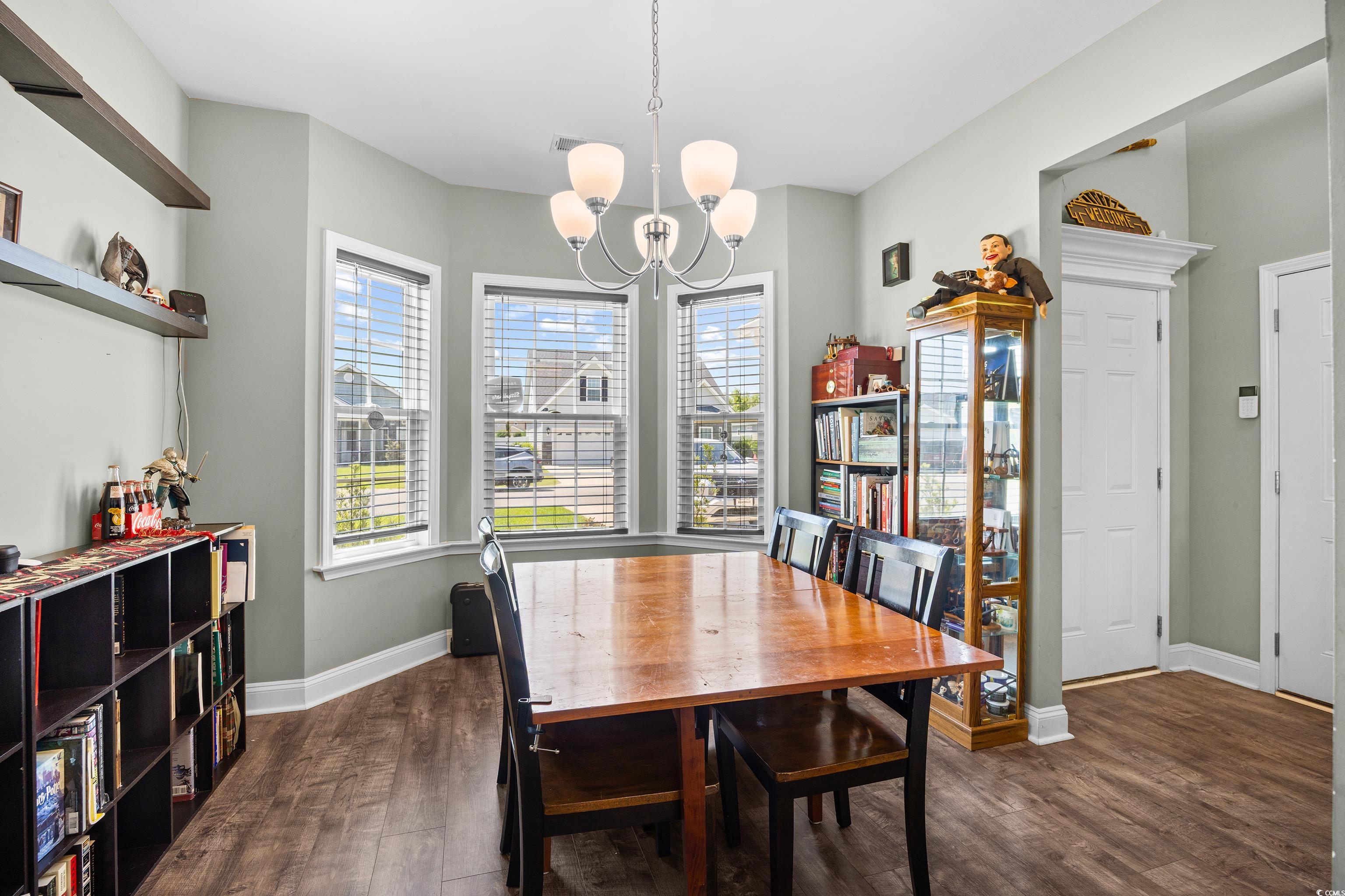 704 Hobonny Loop Longs, SC 29568 - Photo 3 of 36 Dining area with a chandelier and dark wood-style
